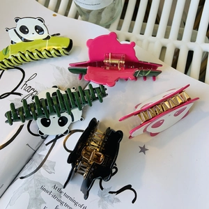 Detalle de varios clips de pelo de panda en acetato en colores verde, rosa y negro