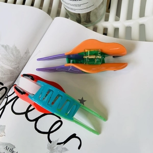 Close-up of vibrant parrot acetate hair claws featuring durable metal springs and sleek teeth
