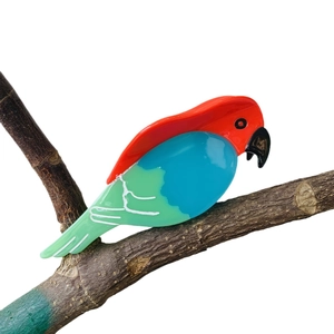 Vibrant parrot acetate hair claw clip for high ponytail styling on a branch