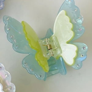 Detailed top view of a layered acetic acid butterfly hair claw with iridescent crystals