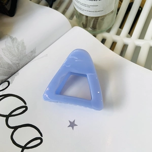 Detailed view of light blue hollow triangle hair claw clip on clean white background