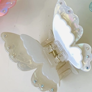 Macro shot of acetic acid butterfly hair claw with iridescent pearls and colorful rhinestones