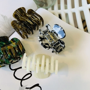 Macro detail of four acetate hair claws in tortoise shell and marble textures