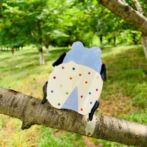 Détail d'une pince à cheveux coccinelle avec strass colorés sur une branche