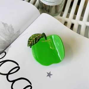 Detailed macro view of high-gloss green apple cellulose acetate fruit hair claw clip