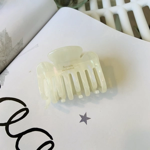 Elegant cream white acetate claw clip with gold lettering for a stylish French hairstyle