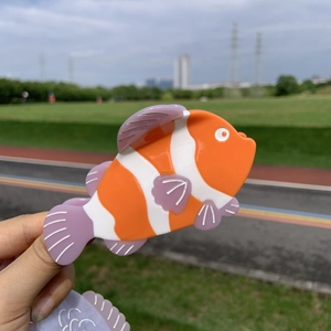 Pince à cheveux poisson-clown orange avec rayures blanches et détails de nageoires mauves
