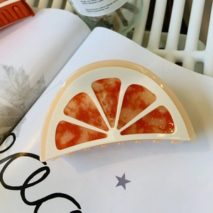 Orange slice acetate hair claw clip with realistic fruit texture for stylish updos