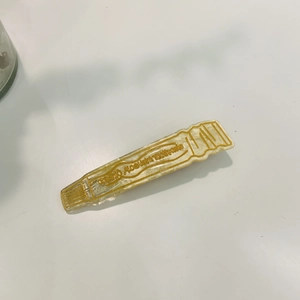 Détail de la pince à cheveux en acide acétique jaune en forme de tube de dentifrice