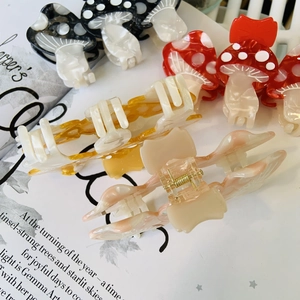Cute mushroom acetate hair claws in various colors displayed on a fashion magazine