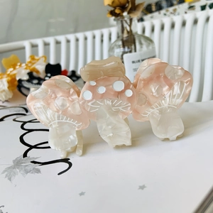 Detail of pink marbled mushroom hair claw clip made of acetate with white polka dots texture
