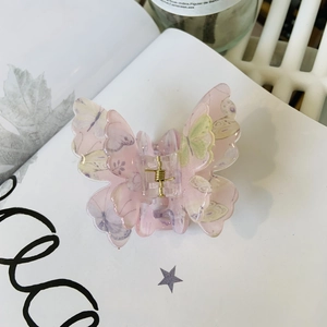 Détail de la pince à cheveux papillon en acrylique rose multicouche à motifs floraux