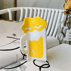 Kreative Haarklammer im Bierkrug-Design mit gelber Flüssigkeit auf minimalistischem Hintergrund