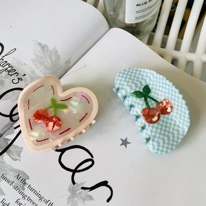 Détail de pince à cheveux coeur nacré et barrette à motif vichy bleu avec cerise