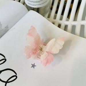 Double-layer butterfly hair claw clip with pink gradient marble effect and glitter finish