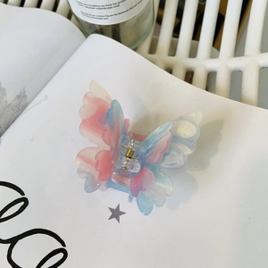 Detail view of double-layered butterfly hair claw with dreamy pink-blue marble texture