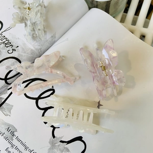 Lot de pinces à cheveux en acétate irisées papillon et rectangulaires sur un magazine