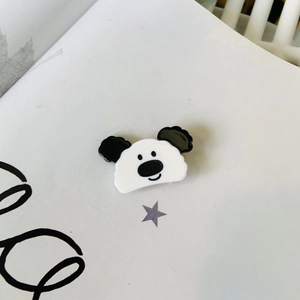 Macro shot of cute panda acetate hair clip detail on white background with minimalist decor