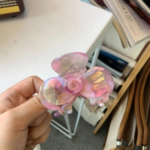 Dettaglio della molletta per capelli a camelia rosa cangiante con finitura in acetato