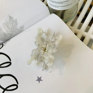 Pince à cheveux papillon élégante avec texture marbrée crème et détails en métal doré