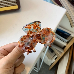Dettaglio del fermaglio per capelli in acetato con trama tartarugata multicolore