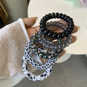 Detail view of spiral telephone cord hair ties in assorted black and floral patterns