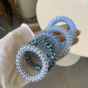 Close-up of assorted spiral telephone cord hair ties in solid colors and floral patterns