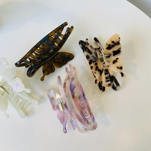 Détail des pinces à cheveux papillon en acétate avec motifs écailles et nacrés élégants