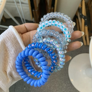 Close-up of spiral telephone cord hair ties in assorted blue patterns and floral styles