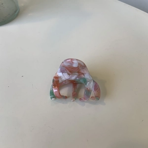 Detail of pink and green marbled acetate hair claw with Barrette la France gold lettering