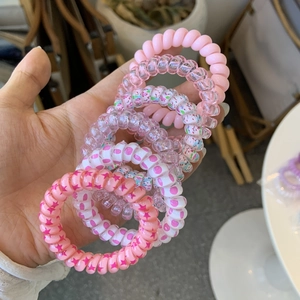 Detail of pink spiral telephone wire hair ties with various patterns and high elasticity