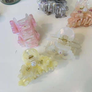Detail of assorted acetic acid hair claws with elegant pearl flower and marble patterns