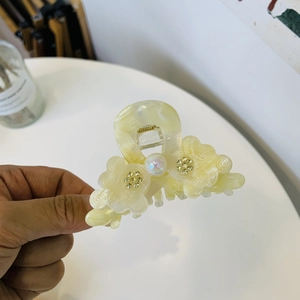 Elegant floral acetate hair claw clip with pearl center and sparkling rhinestone petals