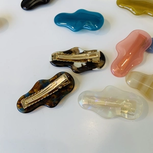 Flat lay of irregular wave duckbill hair clips with tortoise shell and marble patterns