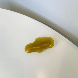 Detailed macro view of an amber resin hair clip with a handmade engraved text