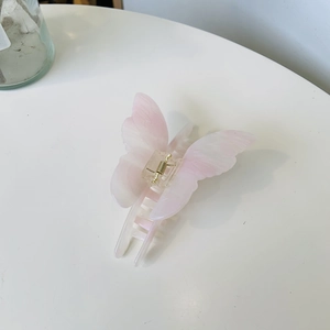 Elegant pink butterfly hair claw clip with marble texture and golden spring mechanism