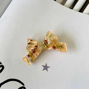 Floral resin bow hair clip with dried flowers and pearls in amber finish