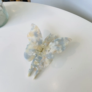 Elegant acetate butterfly hair claw clip with blue marble pattern and gold metal spring