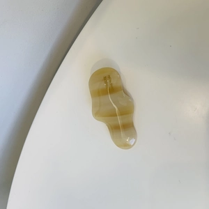 Detail view of wavy amber resin hair clip with SUNSHINE handmade text engraving