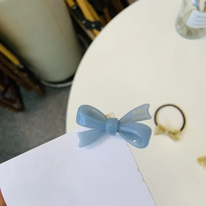 Vue détaillée de la pince à cheveux nœud bleu brillant avec inscription dorée France