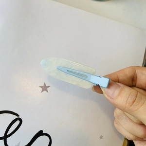 Dettaglio del fermaglio per capelli in resina glitter con blocchi di colore blu e bianco