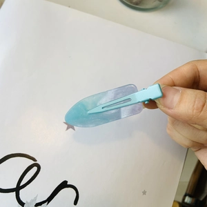 Dettaglio del fermaglio per capelli in resina sfumata blu viola con glitter scintillanti