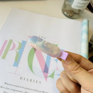 Détail d'une pince à cheveux marbrée bleu et rose avec un fini nacré étincelant