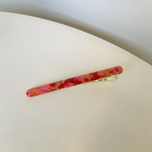Elegant floral resin hair clip with pink and red marble patterns on golden base