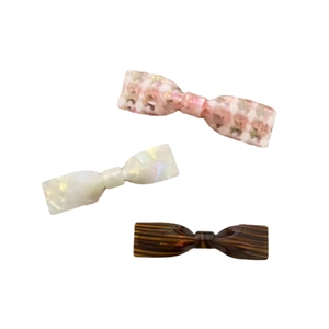 Trois barrettes à nœuds en acétate avec motifs floral rose, perle et écaille de tortue