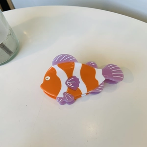 Dettaglio dall'alto di una pinza per capelli a forma di pesce pagliaccio in acetato