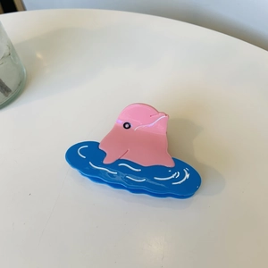 Dettaglio della molletta per capelli a delfino rosa in acetato lucido serie oceano