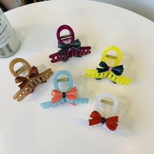 Detailed collection of five bow-shaped acetic acid hair claws in vibrant contrast colors