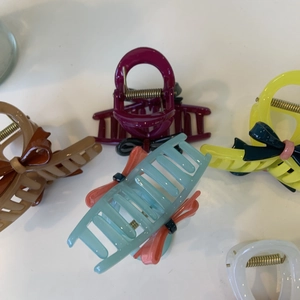 Close-up of assorted colorful acetate bow hair claws in brown red and mint green