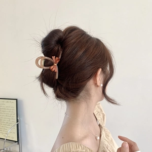 Close-up of a brown bow acetate hair claw clip worn on a woman's elegant updo